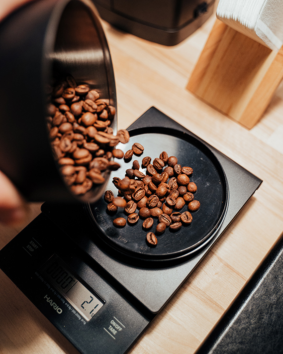 a barista weighs out coffee beans for grinding