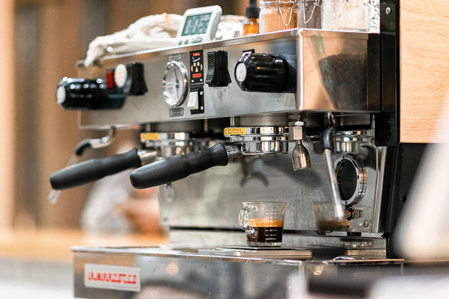 an espresso machine with portafilters attached preparing coffee