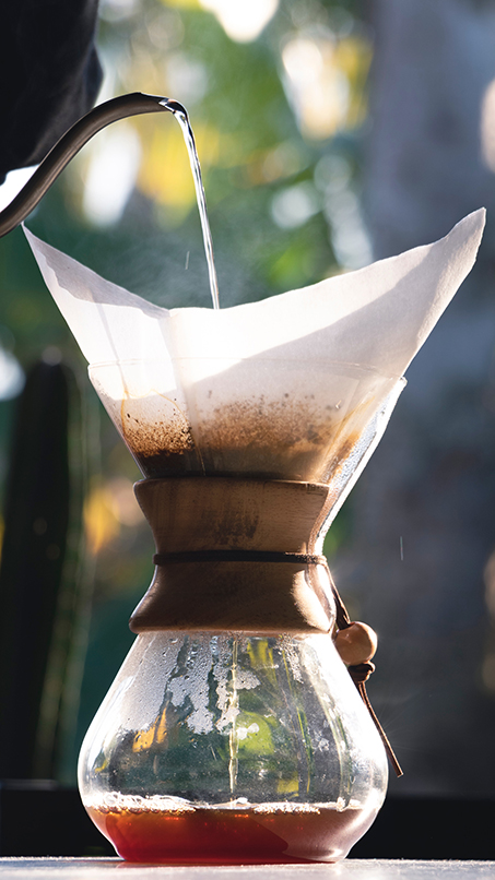 hot water being poured into a chemex with filter